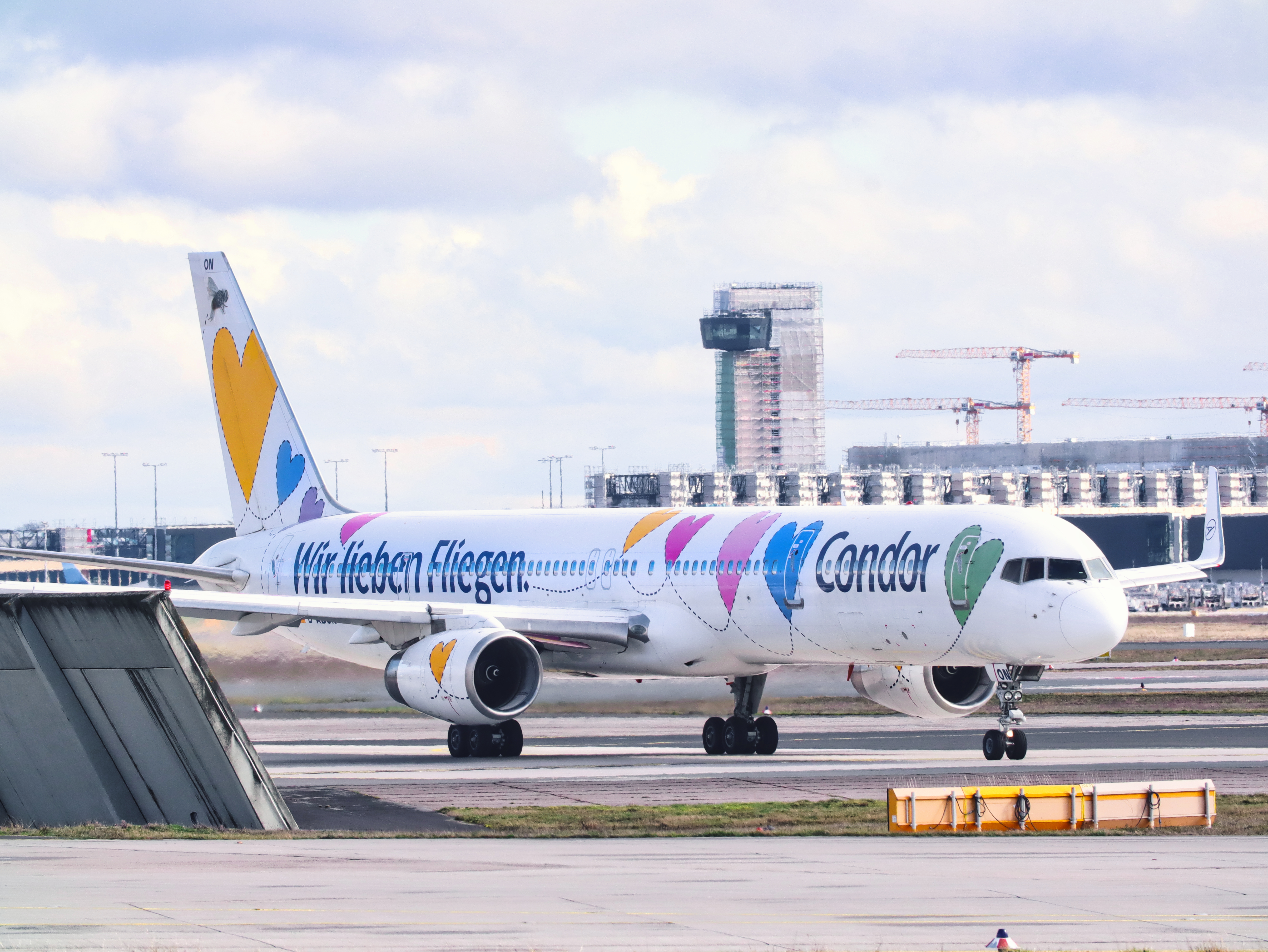 Condor aircraft with special heart livery and the lettering “We love flying” on the tarmac.
