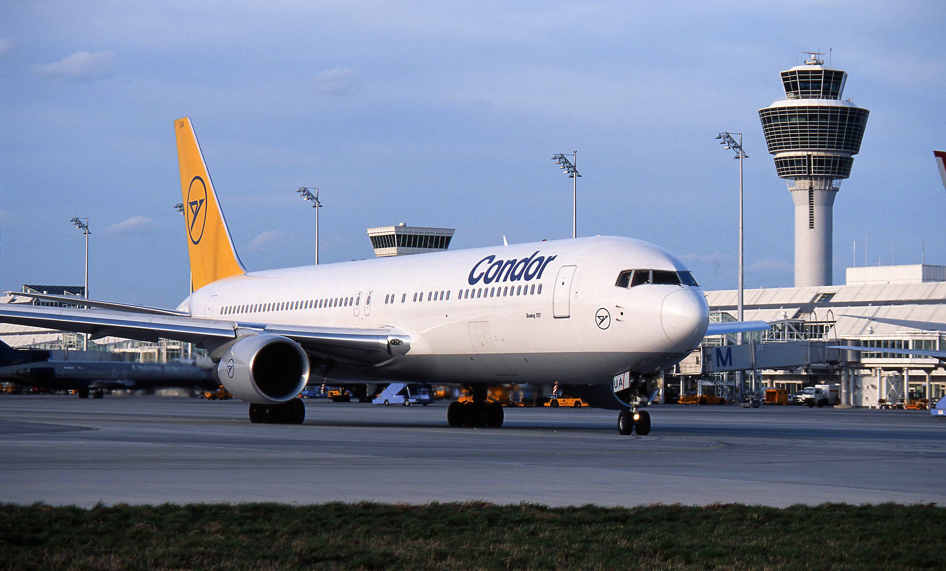 Historic passenger plane with a yellow tail unit on an airport apron.