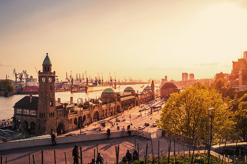 Hamburg harbor with Landungsbrücken and the Elbe at sunset.